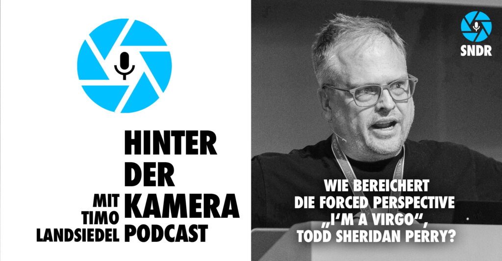 Neben dem Logo des Hinter der Kamera Podcasts, eine hellblaue, stilisierte Kamerablende mit sechs Lamellen in deren Zentrum ein Mikrofon-Piktogramm prangt, sehen wir das kontraststarke, schwarz-weiß Porträt von zwei Personen, links im BIld Christina Caspers-Römer mit dunkler Audrey-Hepburn-Brille und hellem Kapuzenpulli, in die Kamera lächelnd. Daneben Tobias Stärk, mit grau meliertem kurzen Bart schmunzelnd, ebenfalls im Kapuzenpulli. Darunter der Titel dieser Sonderfolge: Welche Rolle spielt die Virtual Production in Zukunft, Todd Sheridan Perry? Fotos: Timmo Landsiedel